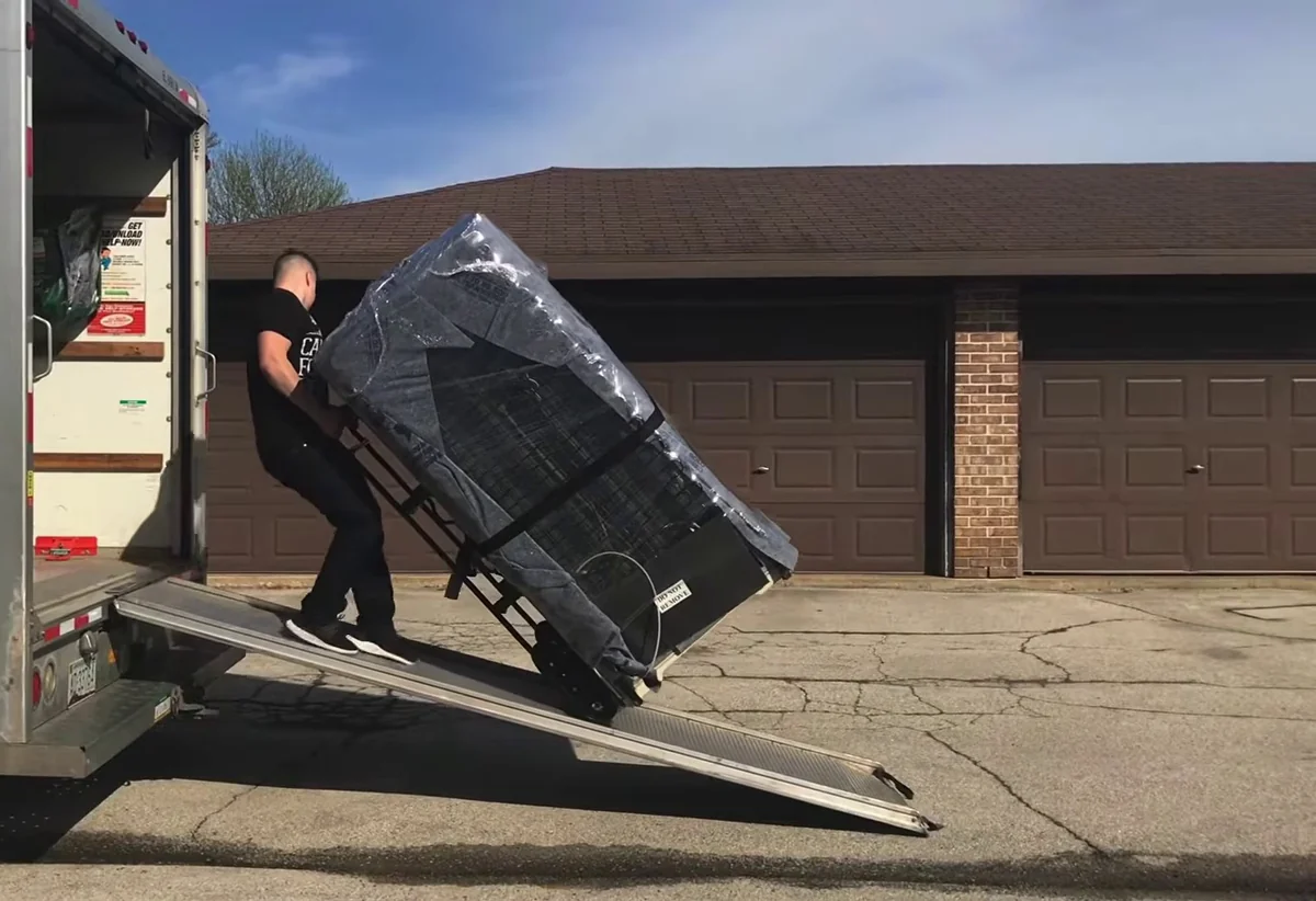 Lionheart furniture movers carrying wrapped furniture in Bossier City